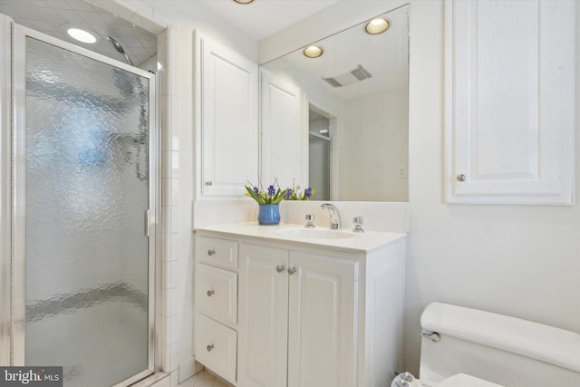 bathroom with toilet, walk in shower, and vanity