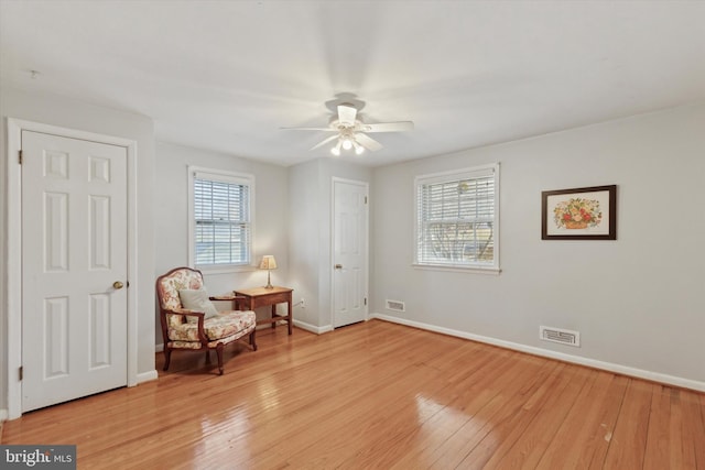 sitting room featuring light hardwood / wood-style floors, ceiling fan, and a wealth of natural light