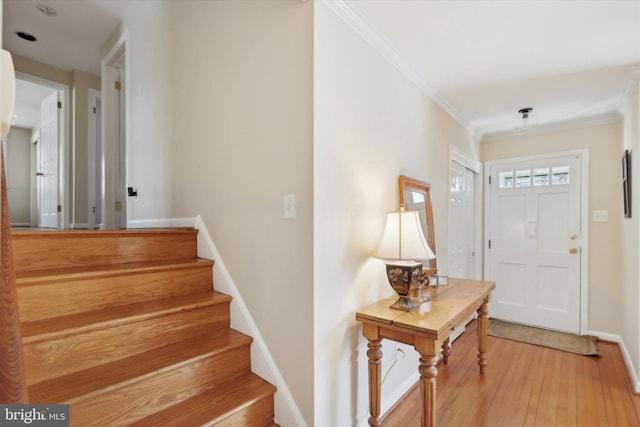 foyer featuring light wood-type flooring and crown molding