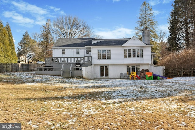 snow covered rear of property featuring a deck