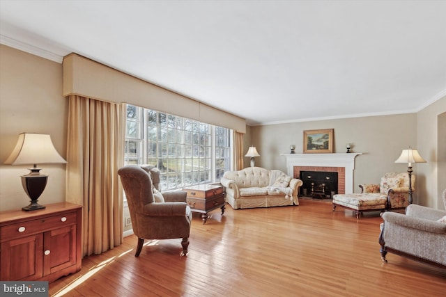 living room with a brick fireplace, crown molding, and light hardwood / wood-style flooring