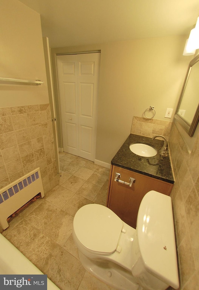 bathroom featuring vanity, toilet, and radiator heating unit