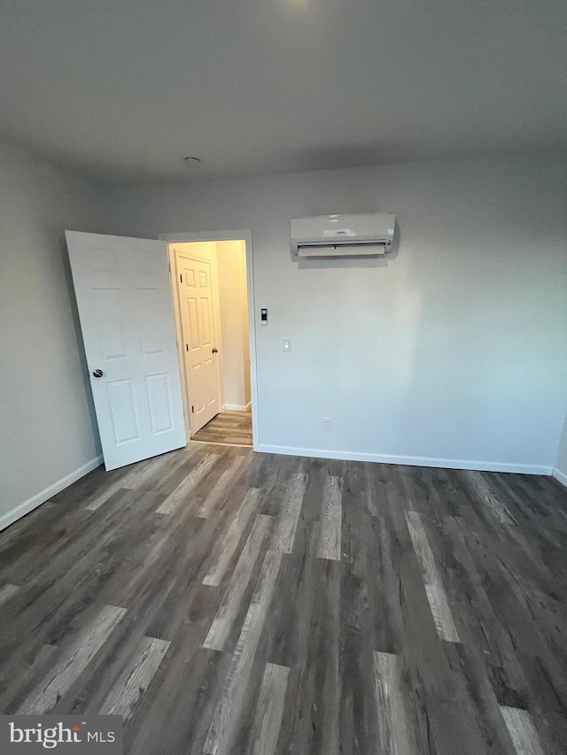 spare room with dark hardwood / wood-style floors and a wall mounted AC