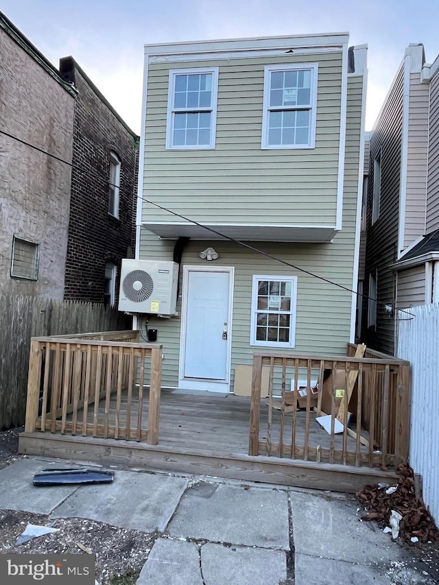 back of property with ac unit and a deck