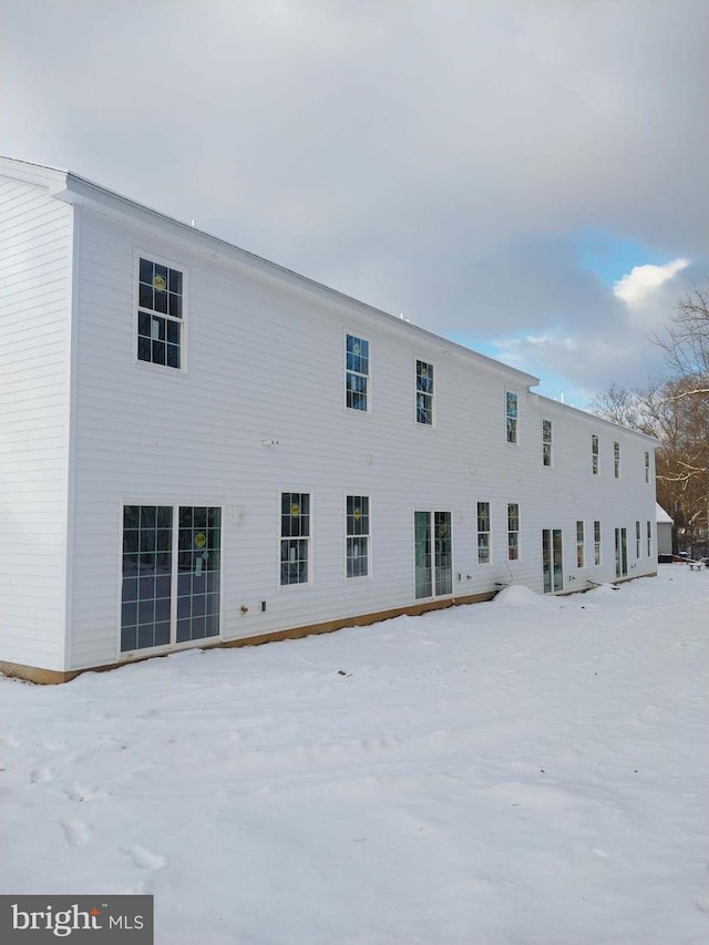 view of snow covered back of property