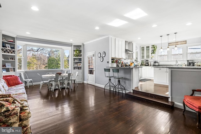 dining room with dark hardwood / wood-style flooring, crown molding, and sink