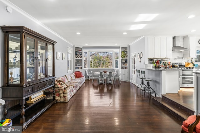 living room featuring dark hardwood / wood-style flooring, crown molding, and built in features