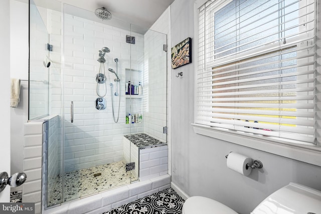 bathroom with tile patterned floors, a shower with shower door, and toilet