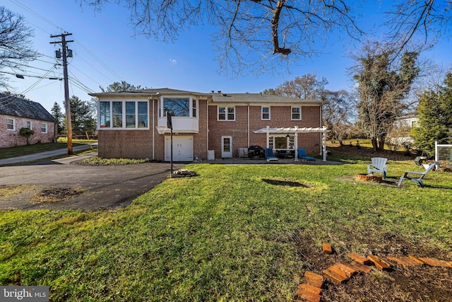 rear view of house featuring a yard, a pergola, and a garage