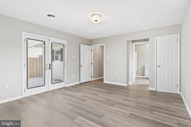 unfurnished bedroom with french doors and light hardwood / wood-style floors