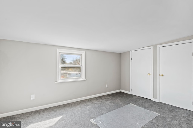 unfurnished bedroom featuring dark carpet