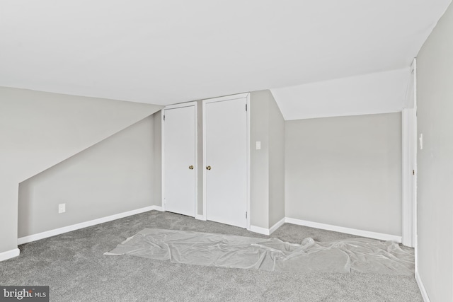 bonus room featuring light carpet and vaulted ceiling