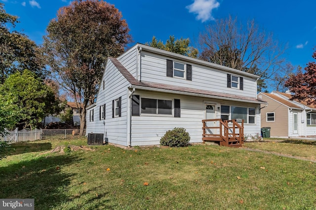 front of property featuring central AC unit and a front yard