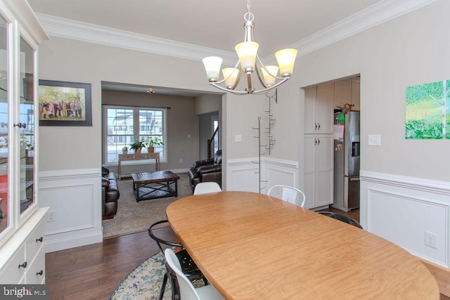 dining room with a notable chandelier, ornamental molding, and dark wood-type flooring