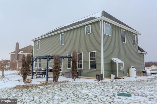 snow covered property with a pergola