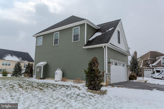 snow covered property with a garage