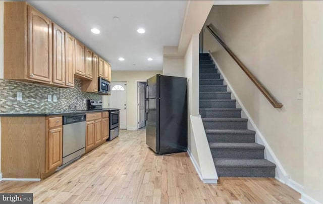 kitchen featuring light hardwood / wood-style flooring, appliances with stainless steel finishes, and tasteful backsplash