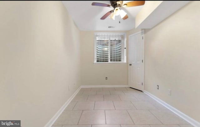 empty room featuring ceiling fan and light tile patterned floors