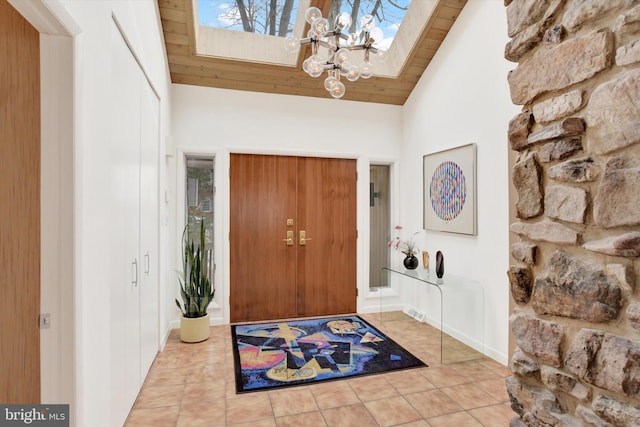 entryway featuring high vaulted ceiling, wood ceiling, light tile patterned floors, and an inviting chandelier