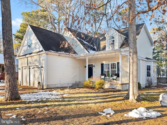 cape cod house featuring a porch and a garage