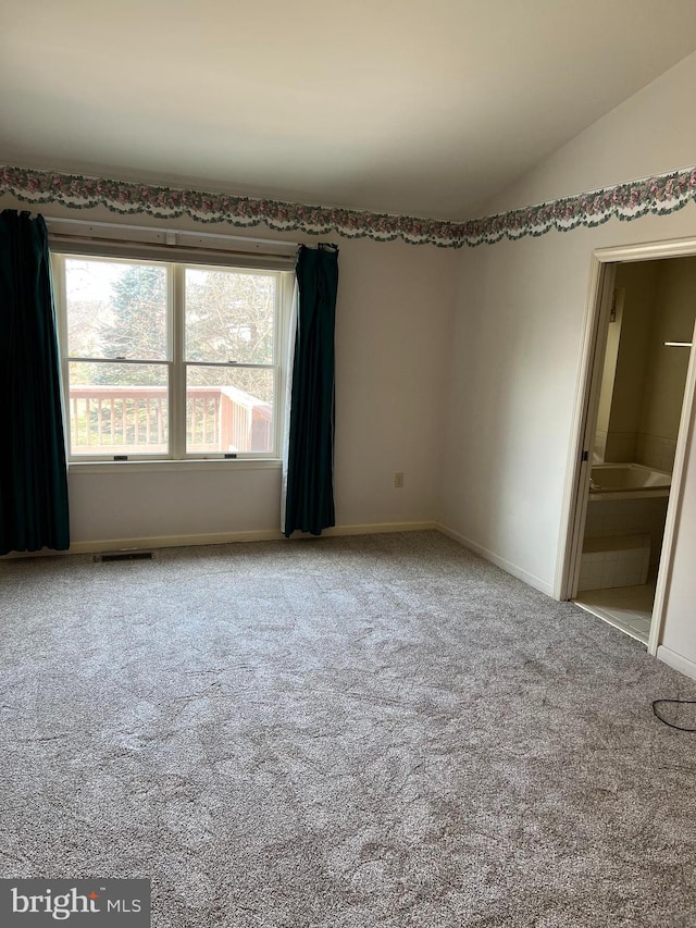 carpeted empty room with a healthy amount of sunlight and lofted ceiling