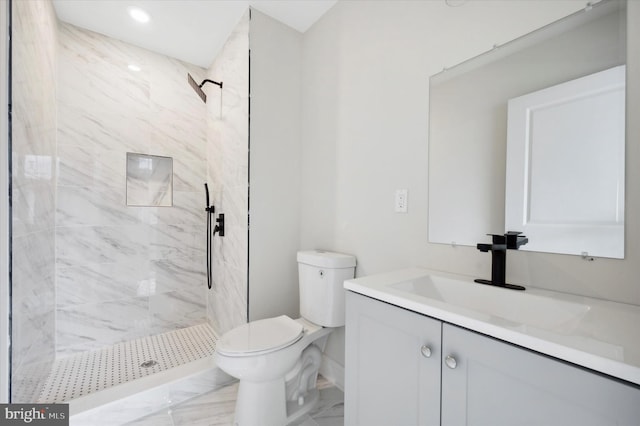 bathroom with vanity, toilet, and a tile shower