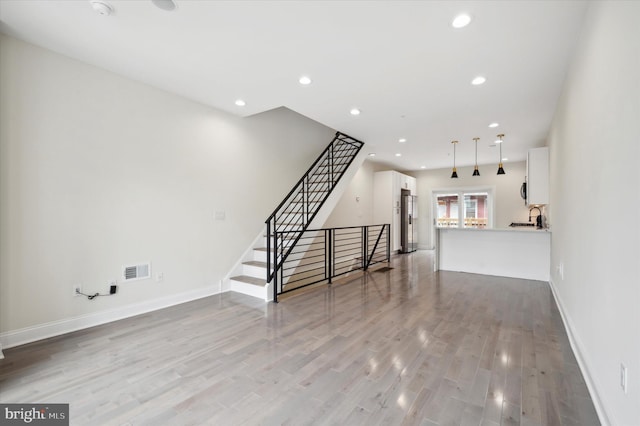 unfurnished living room with french doors, light hardwood / wood-style floors, and sink