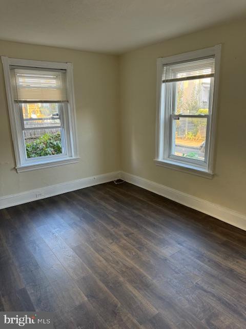 unfurnished room with dark hardwood / wood-style floors