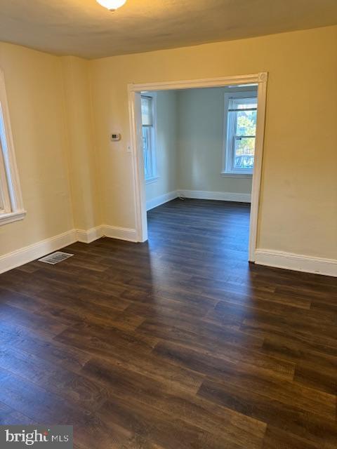 empty room with dark hardwood / wood-style flooring