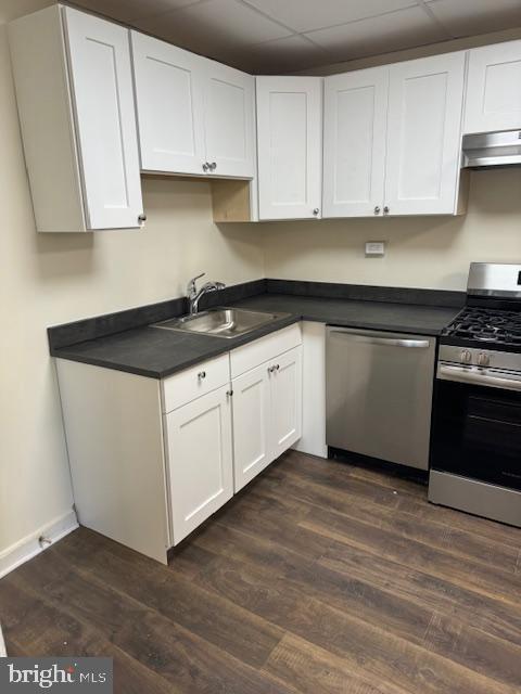 kitchen with a paneled ceiling, white cabinetry, sink, and appliances with stainless steel finishes