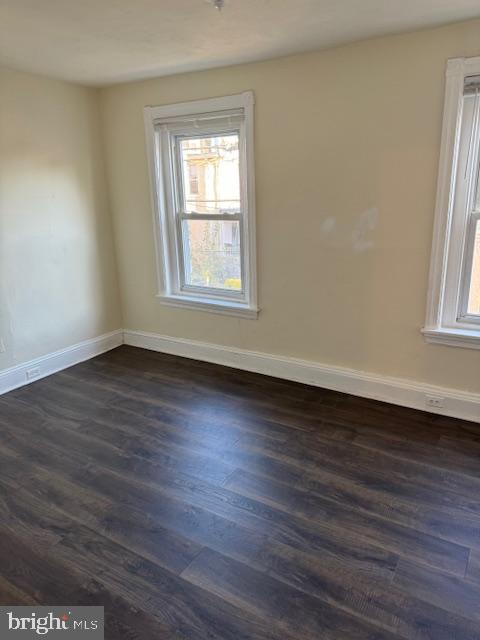 empty room featuring dark hardwood / wood-style floors and a wealth of natural light