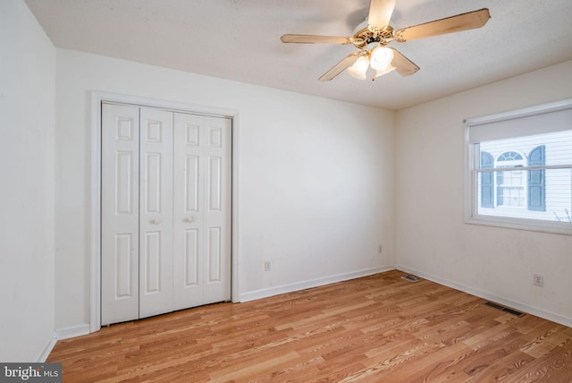 unfurnished bedroom featuring a closet, ceiling fan, and light hardwood / wood-style flooring