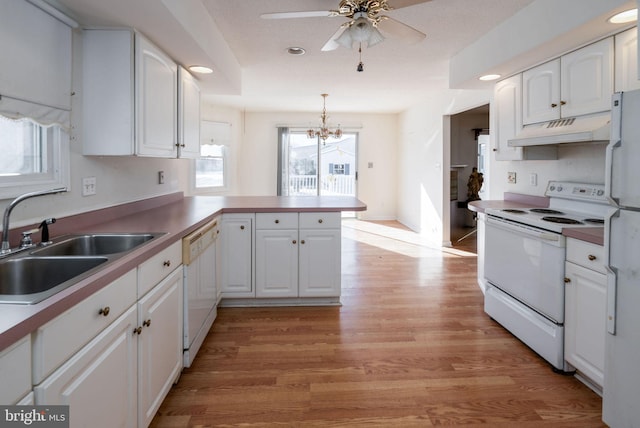 kitchen featuring kitchen peninsula, white appliances, white cabinets, and sink