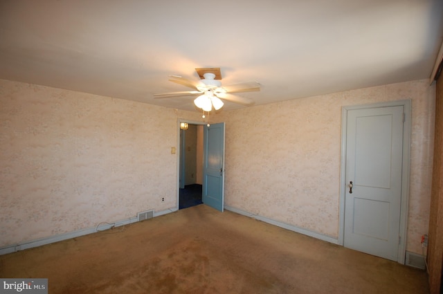 carpeted spare room featuring ceiling fan