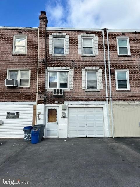 view of front of property featuring a garage and cooling unit