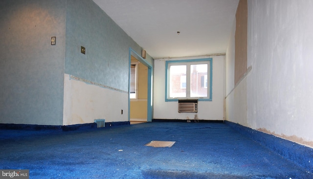 spare room with carpet floors and an AC wall unit