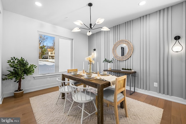 dining space featuring hardwood / wood-style flooring and an inviting chandelier