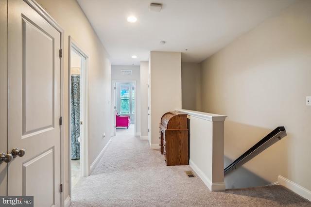 hall with light colored carpet