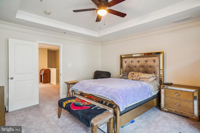 bedroom featuring light carpet, a tray ceiling, ceiling fan, and ornamental molding