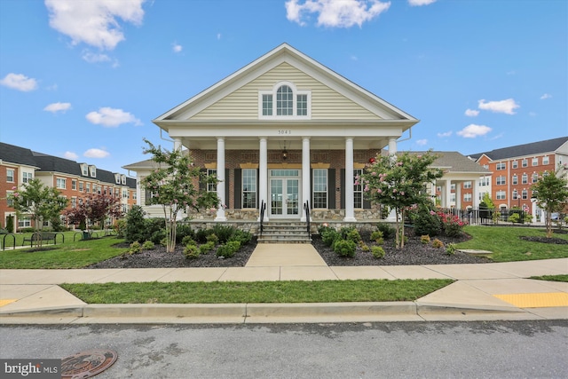 greek revival inspired property with a front yard and a porch