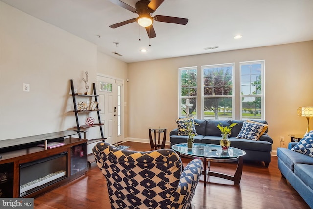 living room featuring ceiling fan and dark hardwood / wood-style flooring