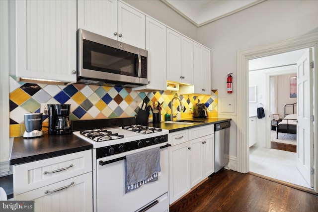 kitchen with decorative backsplash, white cabinetry, and stainless steel appliances