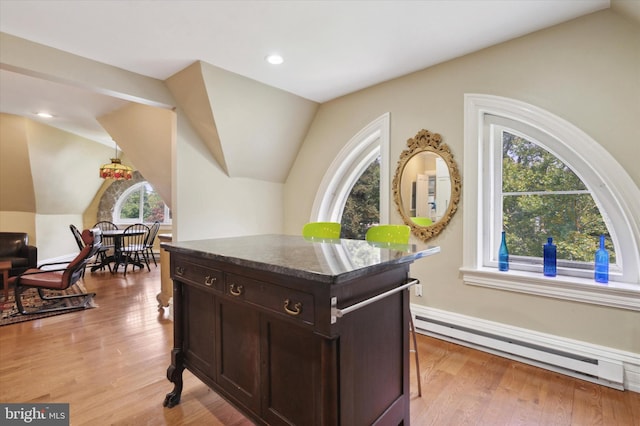 office with light hardwood / wood-style floors, vaulted ceiling, and a baseboard radiator