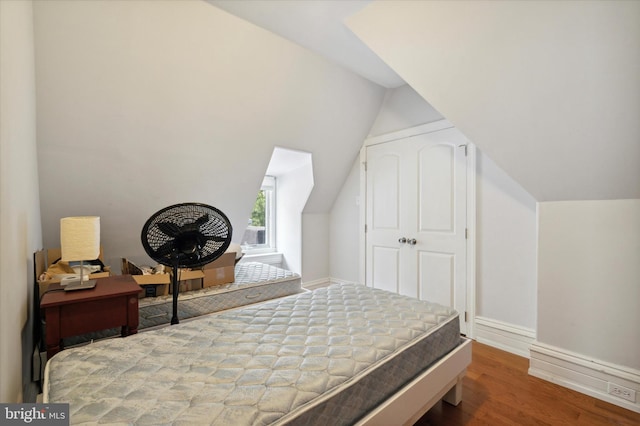 bedroom featuring hardwood / wood-style flooring and lofted ceiling