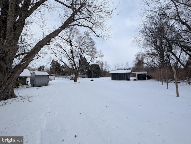 yard layered in snow with an outbuilding