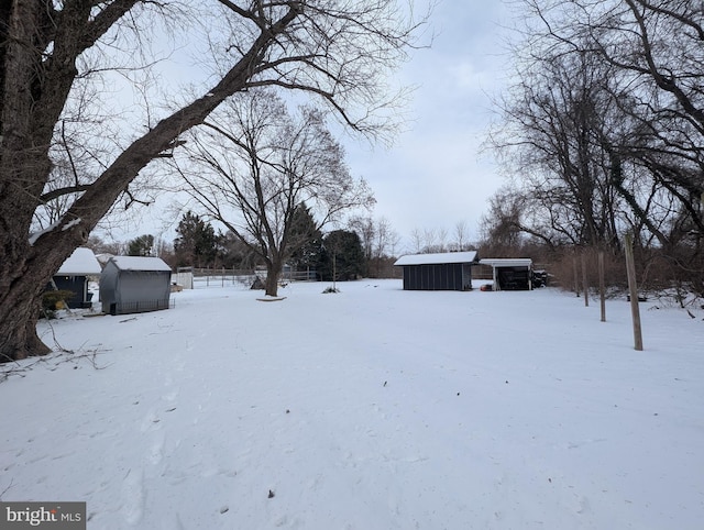 snowy yard featuring an outbuilding