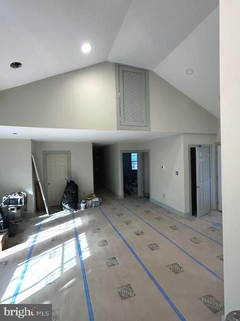 unfurnished living room featuring high vaulted ceiling