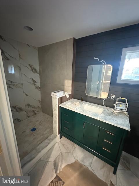 bathroom featuring a tile shower and vanity