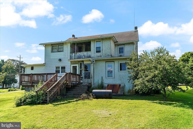 back of house featuring a wooden deck and a lawn