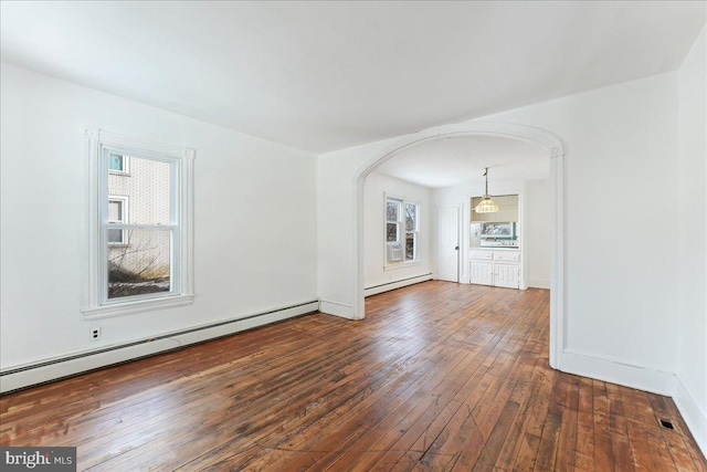 unfurnished living room featuring dark wood-type flooring and a baseboard heating unit